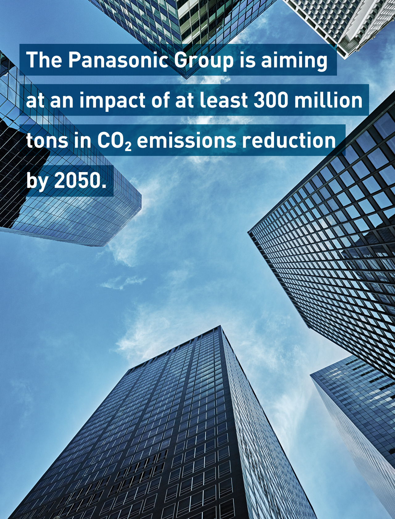 The Panasonic Group is aiming at an impact of at least 300 million tons in CO2 emissions reduction by 2050. Background photo: Tall skyscrapers viewed from below against a blue sky.