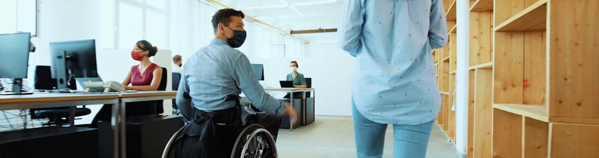 Photo: An employee using a wheelchair moving around the office