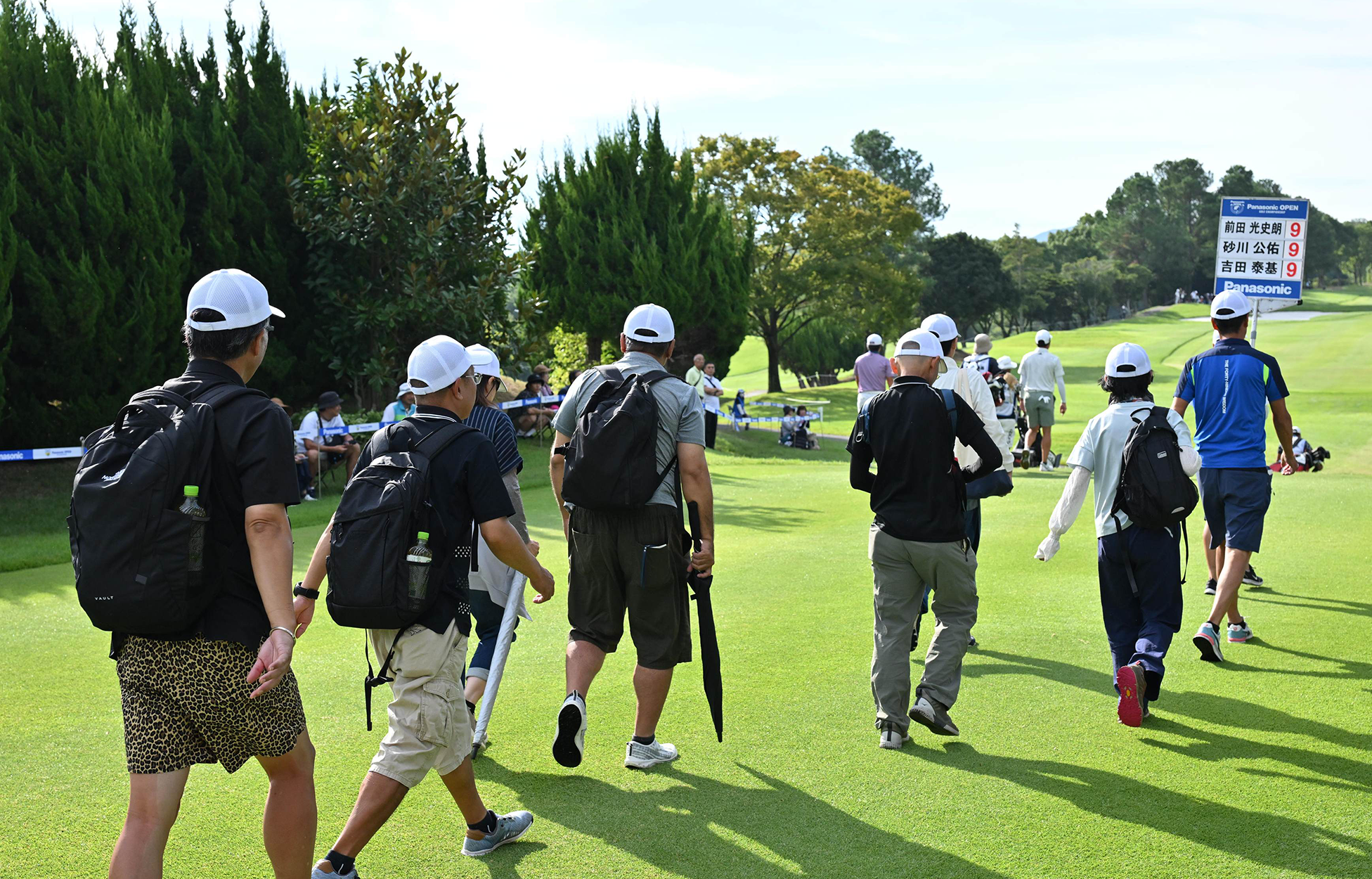 選手のすぐ後ろをついて歩くインサイドロープツアーの参加者たち