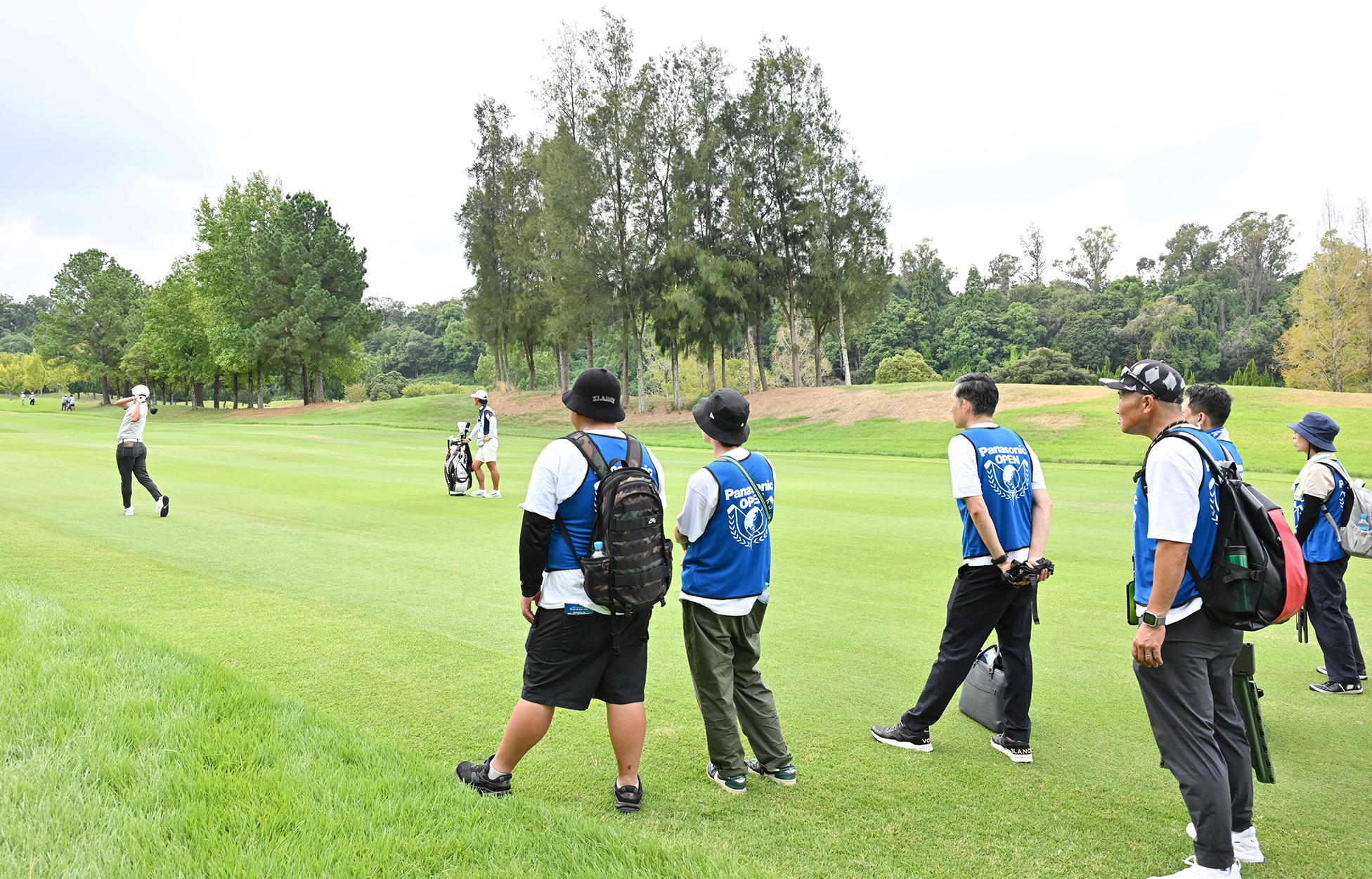 ロープの内側で迫力のショットを観る参加者たち