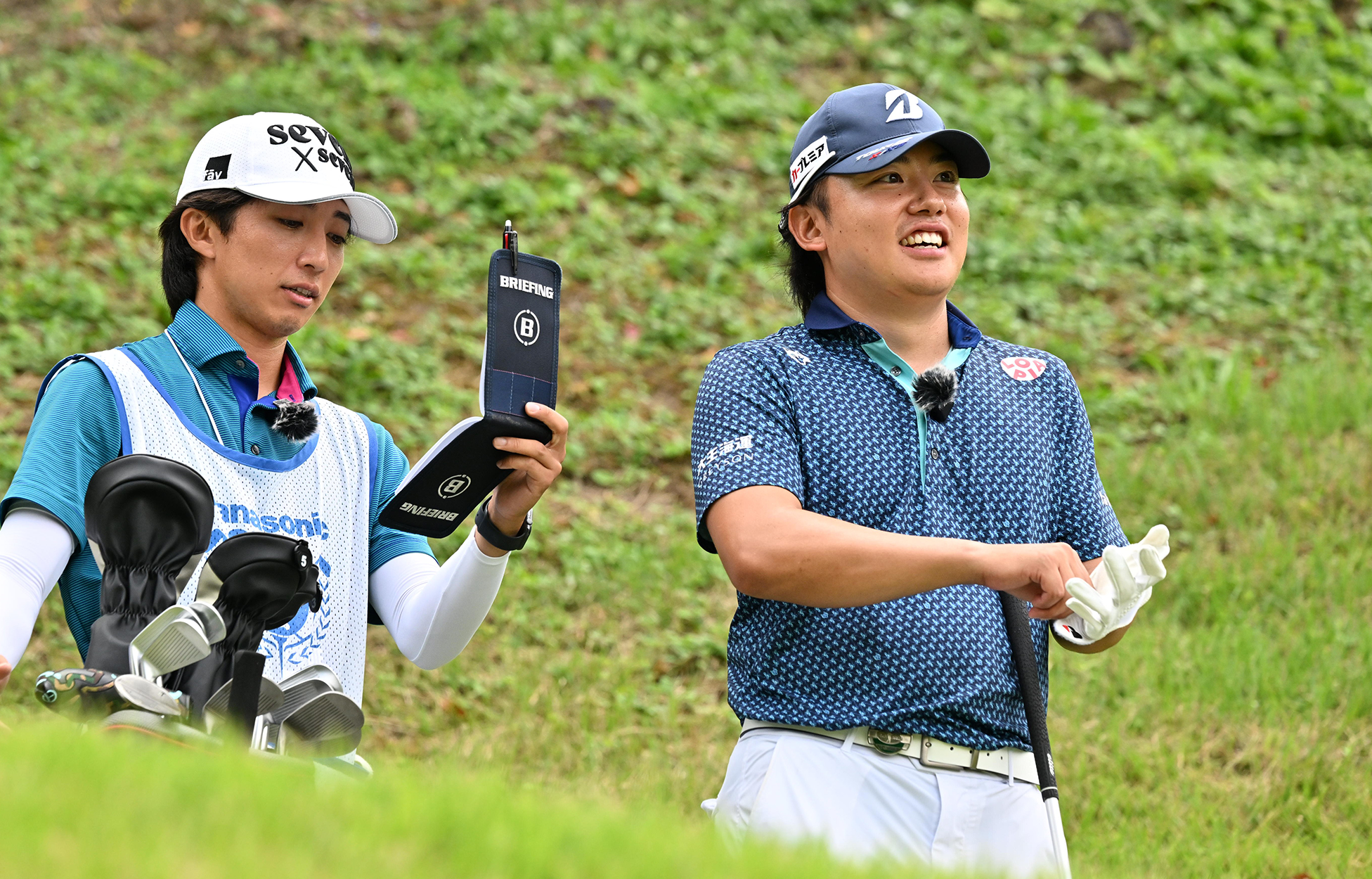 マイクを着けてコース上で会話する清水大成選手とキャディのコンビ