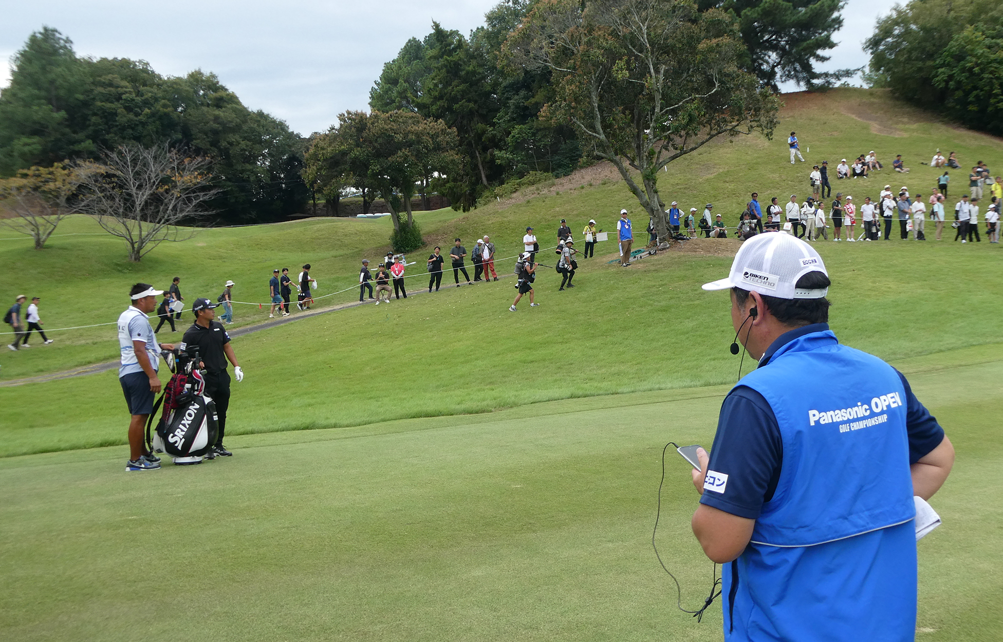 18番ホールで選手を前に解説する小岸キャディ