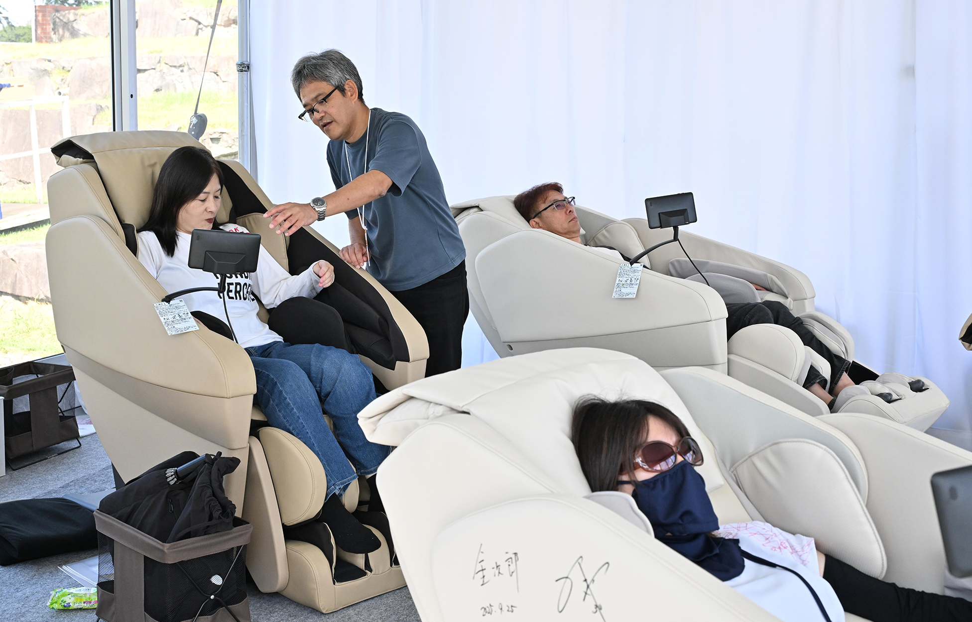 マッサージチェアを体験するギャラリーたち