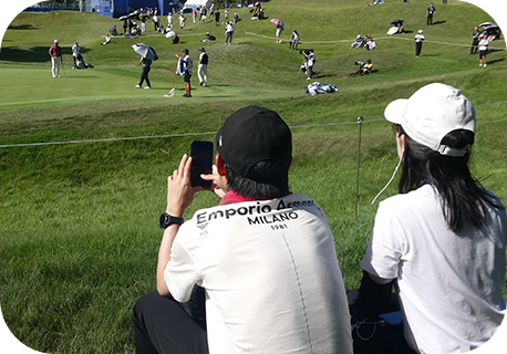 スマホにイヤホンをつけてプレイヤーズマイクを聞く体験者