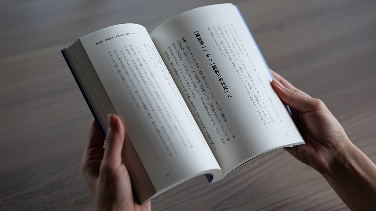 両手で本を開いている