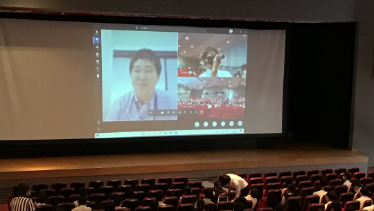 講師、質問する生徒、会場の画面