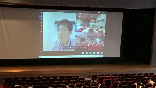 講師、質問する生徒、会場の画面