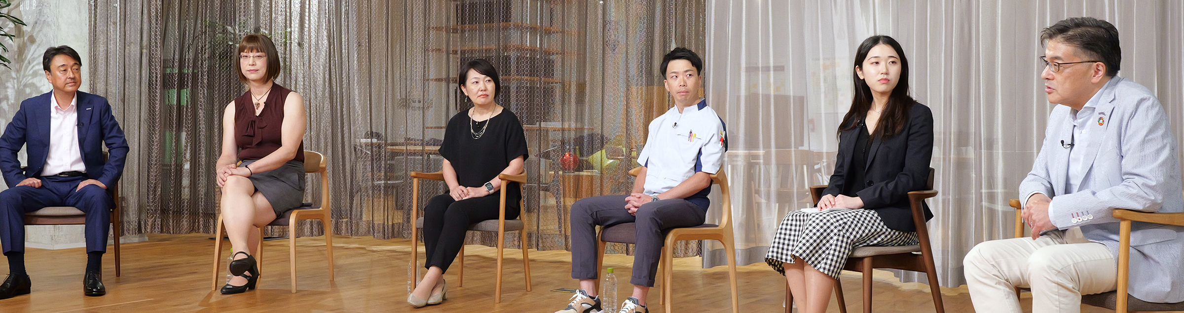 写真：「グループDEIフォーラム 2023」の様子。楠見グループCEO、玉置グループCIOほか4人の登壇者が着席