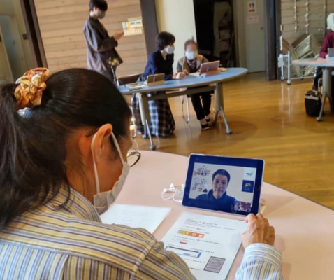 写真:会議室でリモートレッスンのやり方を受講する女性