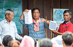 During the hand-over ceremony, an LWD staff member (center) explained to villagers how to use the solar lantern.