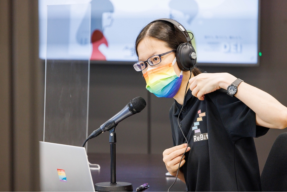 Photo: Nakajima, Director of ReBit, an Approved Specified Nonprofit Corporation, wearing headphones and speaking in front of a microphone