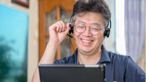 Photo: Image of an employee watching a training seminar on a screen