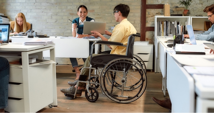 Photo: Image of an employee using a wheelchair working at a desk