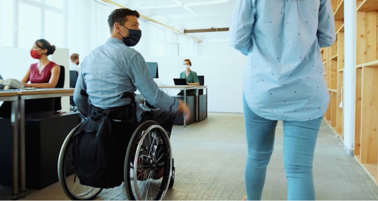 Photo: An employee using a wheelchair moving around the office