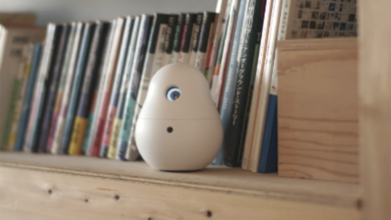 Photo: A communication robot elicits smiles and takes pictures.