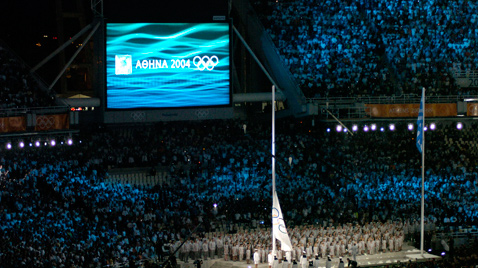 照片：设置在雅典奥运会会场的大型影像显示装置AstroVision上显示的五环标志和雅典奥运会会徽