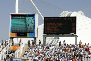 写真：アテネオリンピック会場に設置された大型映像表示装置アストロビジョンに映し出された水泳競技の映像とスコアボード