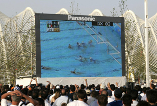 写真：アテネオリンピック会場周辺に設置された大型映像表示装置アストロビジョンに映し出された水泳競技の映像