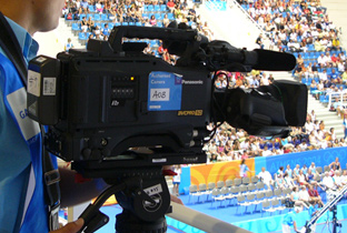 写真：アテネオリンピックの水泳競技会場で放送カメラマンがカメラレコーダーで撮影している様子