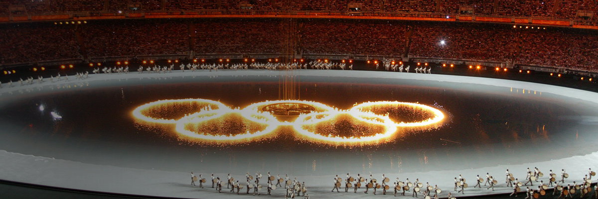 写真：アテネオリンピック開会式セレモニーで、競技場中央のフィールドに炎で描かれた五輪マーク