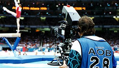 写真：アトランタオリンピックの体操競技会場で放送カメラマンが競技中の選手をカメラレコーダーで撮影している様子