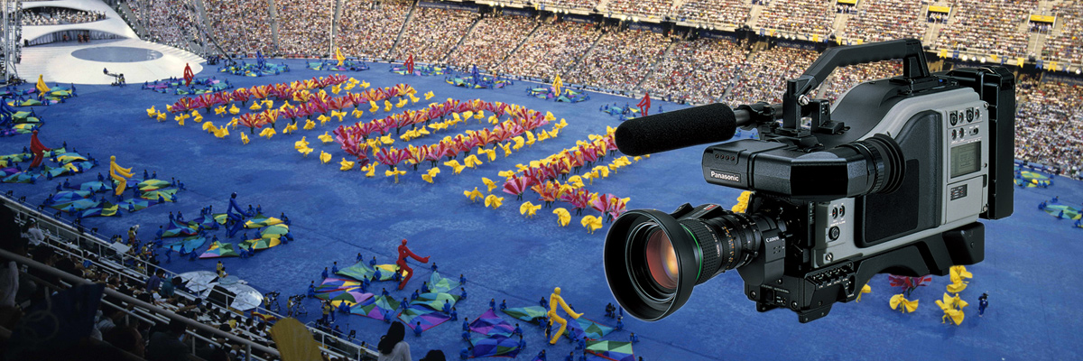 写真：ビデオカメラレコーダーの製品写真とバルセロナオリンピック開会式セレモニーが行われているスタジアムの全景