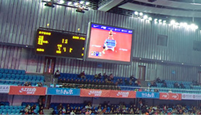 写真：北京大学体育館に設置された大型映像表示装置アストロビジョンに映し出されたスコアボードと卓球競技の映像
