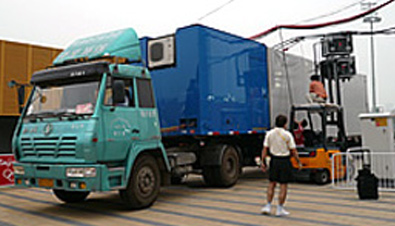 Photo: The large trailer truck carrying the Mobile ASTROVISION display unit passes under low overhead lines being temporarily lifted