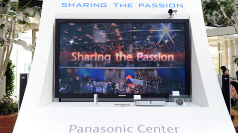 Photo: The words "Sharing the Passion" together with spectators being shown on a monitor installed in the Panasonic booth at a venue of the Olympic Games London 2012