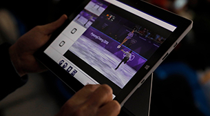 写真：競技会場の観客席でタブレットを使用し、動画配信されたフィギュアスケートの映像を観ている様子