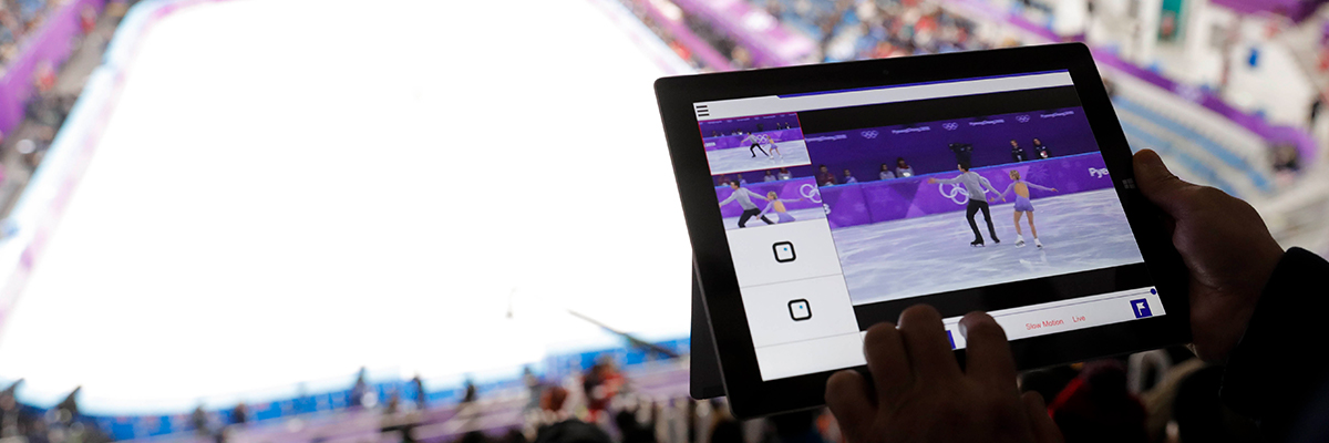 照片：在2018平昌冬奥会的滑冰赛场中，使用平板电脑，观看多视频发布系统上的花样滑冰影像的情景