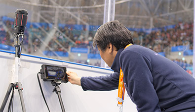 Photo of staff checking footage from a 360-degree live camera via a monitor, installed at a ice hockey competition venue