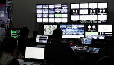 照片：在中央控制室中使用多设备监视系统，对投影机等众多设备进行状态监视和控制的工作人员