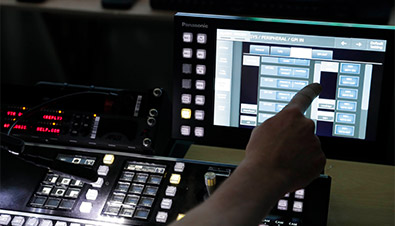 写真：中央制御室でプロジェクターや様々な機器の状態を監視している様子