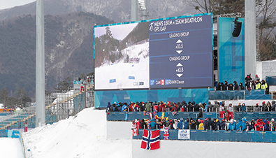 照片：2018平昌冬奥会滑雪赛场中利用大型影像显示装置的组合板上播放的比分等信息和竞技影像