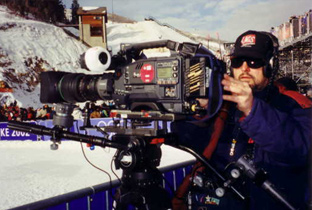Photo: Cameraperson using a camera recorder at one of the venues of the Olympic Winter Games Salt Lake 2002