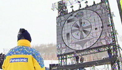 写真：ソルトレイク冬季オリンピック会場での極寒の環境下で設置された大型映像表示装置アストロビジョンの画面表示を確認するスタッフ