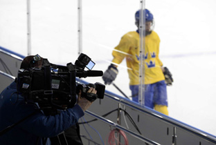 Photo: Cameraperson using an HD camera recorder at an ice hockey venue of the Olympic Winter Games Sochi 2014