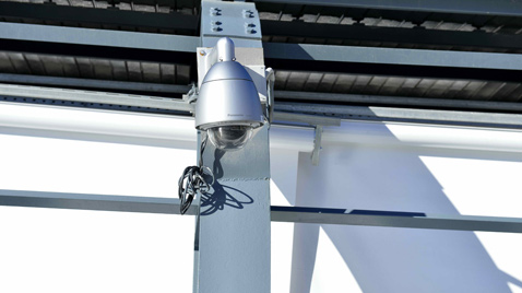 Photo: Outdoor security camera with housing installed on the outside of a building