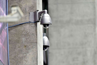 写真：建物の柱に設置された複数の屋外ハウジング一体型セキュリティカメラ
