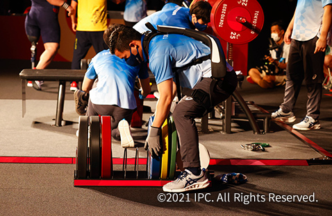 写真：東京2020パラリンピックでパワーアシストスーツ「ATOUN MODELY」を装着しバーベルの重りを持つ補助員