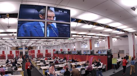 照片：工作人员在IBC（国际广播中心）使用大量显示器进行工作的情景