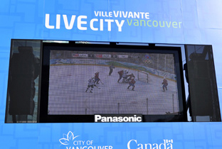 照片：设置在温哥华冬季奥运会会场展台的大型影像显示装置上显示的冰球比赛画面