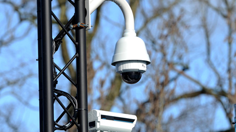 Photo: Dome-type security camera installed on a post outdoors