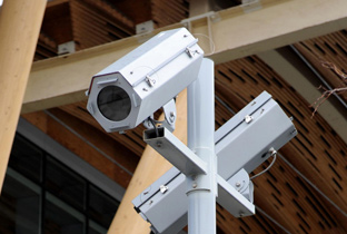 写真：バンクーバー冬季オリンピック会場のスタンドに設置されたハウジングケースに囲われたボックスタイプのセキュリティカメラ