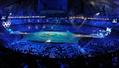 写真：バンクーバー冬季オリンピック会場のメインスタジアムBCプレイスの会場中央に五輪マークが映し出されているセレモニー全景