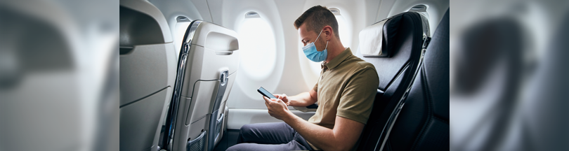 写真：飛行機内で航空会社が提供するコンテンツを見る乗客
