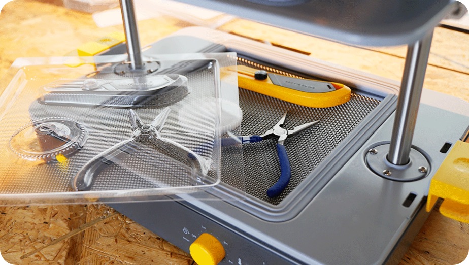 写真：真空成型器と、工具の形に成形されたプラスチック板