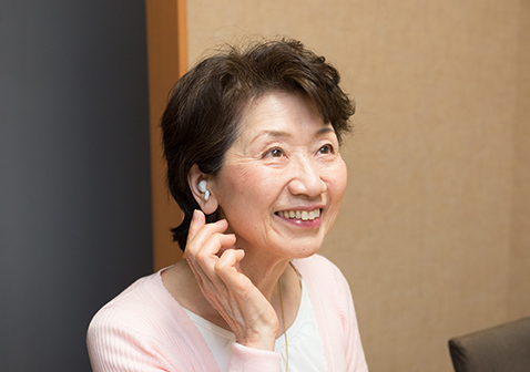 写真：充電式耳あな型補聴器をつけた感じを確認する女性